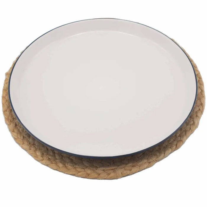 White ceramic plate with navy rim on a woven jute place mat with mandala design