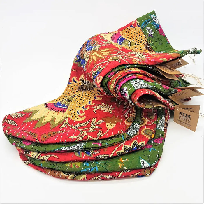 A kantha stitched christmas stocking in red and green with hand-stitched floral and animal quilted patterns