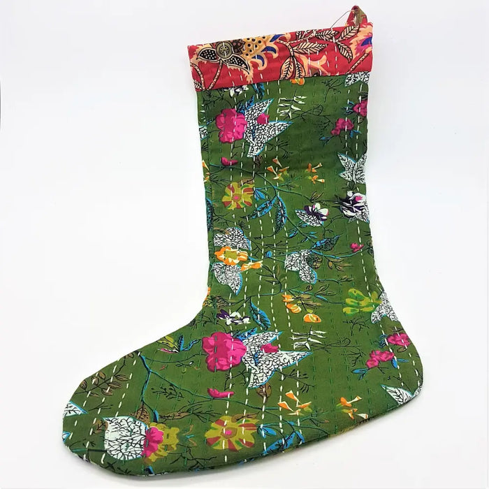A vibrant green kantha stitched christmas stocking with colorful floral patterns and a red embroidered cuff