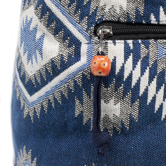 Kathmandu big canvas bag with blue and white geometric patterns and an orange beaded charm on black zipper pull