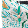 A kathmandu big woven fabric pouch in turquoise green and beige with a black zipper and teal tassel detail