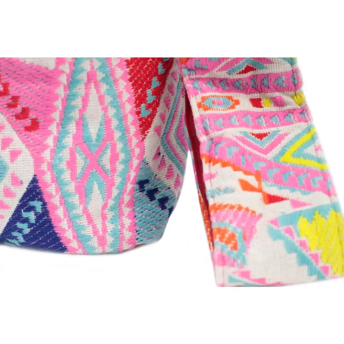 A kathmandu big multicolored woven bag with bold pink turquoise orange and blue geometric patterns on white fabric