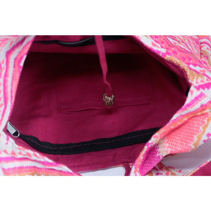 A kathmandu big drawstring bag with vibrant pink and white patterns and a magenta interior lining