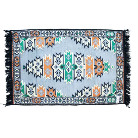 A rectangular kilim rug in charcoal with light blue background and orange green black geometric patterns and dark fringes
