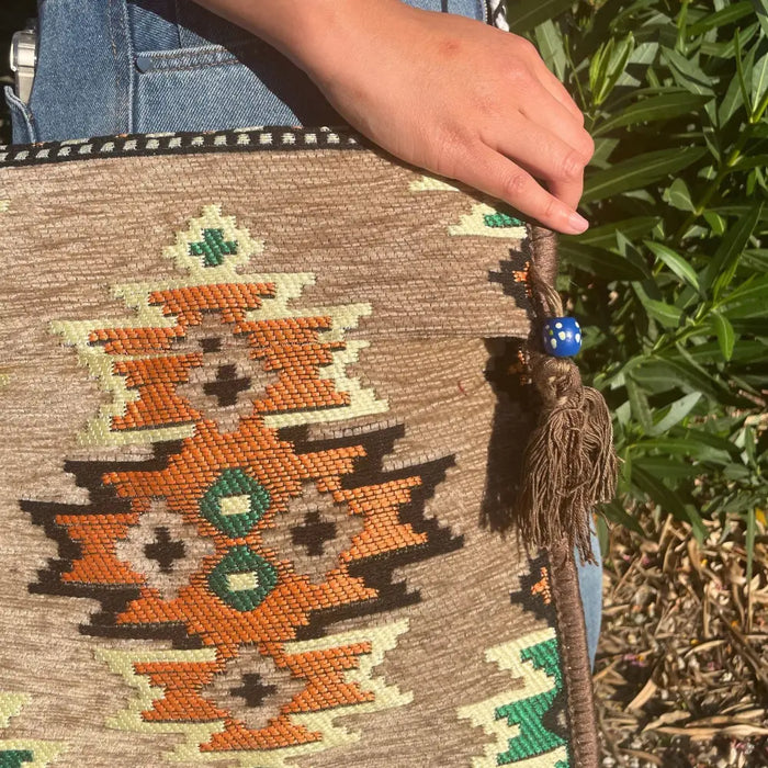 Beige kilim summer messenger bag with woven geometric patterns orange green black braided handle blue bead tassel