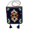 A dark navy Kilim summer messenger bag with embroidered orange green and cream geometric patterns and black tassels