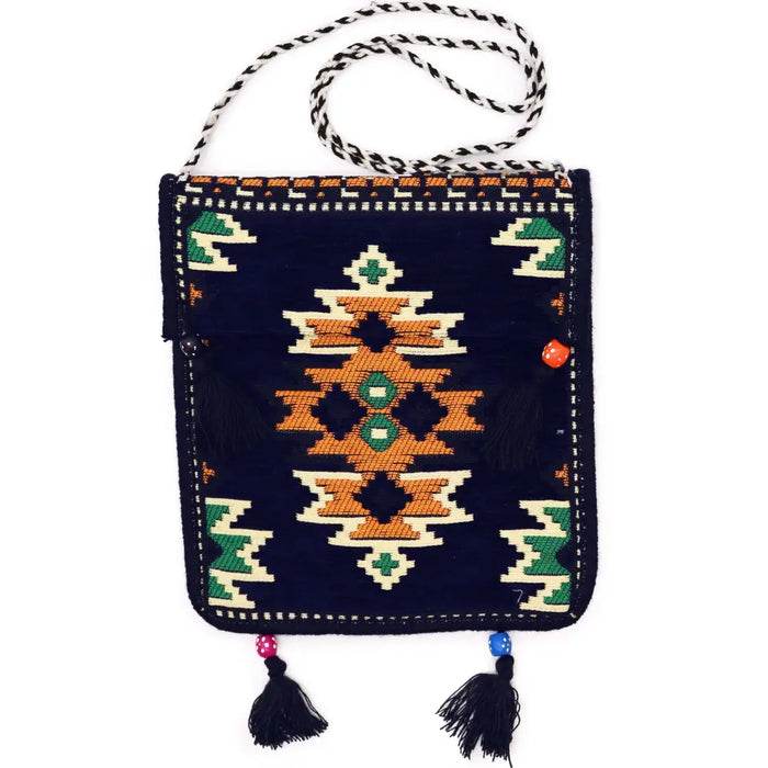 A dark navy Kilim summer messenger bag with embroidered orange green and cream geometric patterns and black tassels