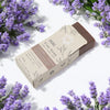 A rectangular brown clay soap bar with a beige taupe wrapper labeled ancient wisdom klay soap lavender vanilla lavandula angustifolia