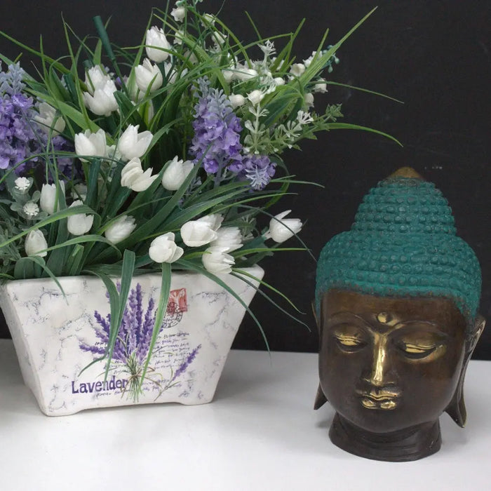 Large brass buddha head statue with teal textured top and gold accents on eyes and lips made of bronze and brass