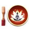 Large red and gold singing bowl set with a black buddha silhouette seated on a lotus flower in black and orange tones