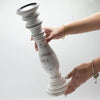 Large whitewash candle stand made of distressed mango wood with a fluted tiered design and black circular top