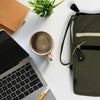 Large olive canvas laptop pouch with beige stripe and black leather accents shown against a white background