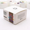 White cardboard box with chakra crystal candle featuring colorful meditating figure and seven chakras illustration