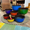 Set of seven singing bowls in large chakra colors with engraved sanskrit mantras including a blue bowl and black rims