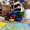 Large chakra set of seven singing bowls in blue green red and yellow with engraved sanskrit mantras on metal rims