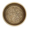A large brass singing bowl with intricate engravings of five buddha figures and ornate patterns