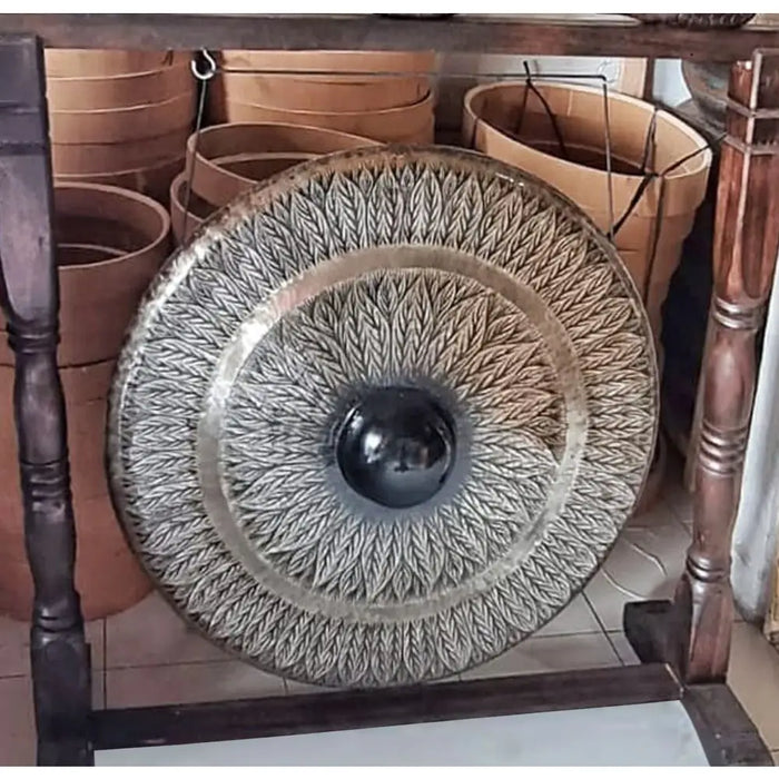 Large bronze gong with black knob and leaf pattern on a stand measuring 80cm