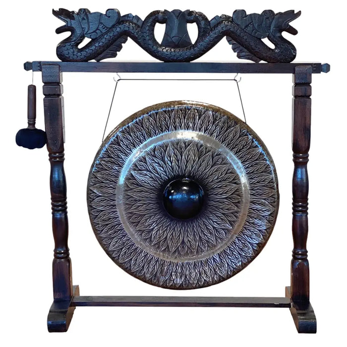 A large black wooden stand with carved dragon motifs holding a patterned 80cm metal gong with leaf engravings