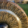 A large translucent amber glass gong with black tree branch patterns on a stand measuring 80cm