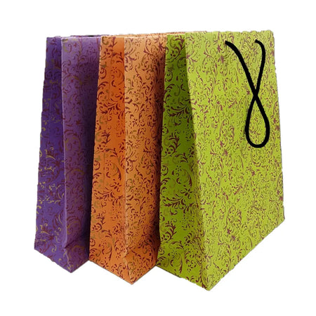 Three large handmade gift bags in purple orange and lime green with ornate floral prints and black twisted handles