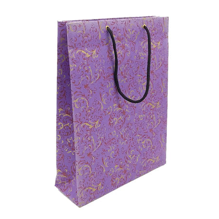 A large handmade gift bag in purple with an ornate gold and maroon floral pattern and black twisted handles