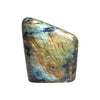 A polished madagascar labradorite stone with blue and gold iridescent flashes on a smooth dark surface weighing 550-750gm