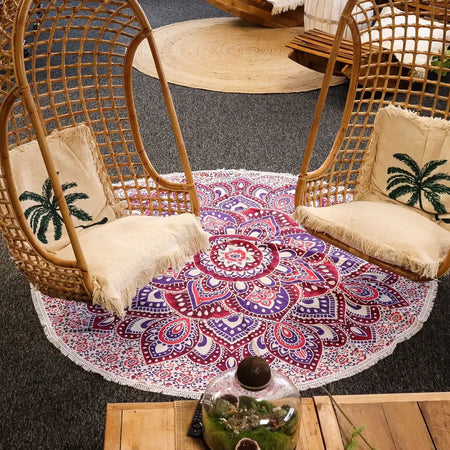 A large cotton mandala roundy blanket in pink and purple with intricate patterns and a fringed edge
