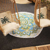 A large circular beach towel with fringes featuring a vibrant blue green and yellow mandala design