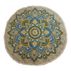 A large round mandala beach towel with fringes in yellow blue and green on a cream background
