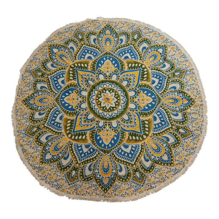 A large round mandala beach towel with fringes in yellow blue and green on a cream background