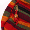 A large nepal sling bag with vibrant multicolored stripes, brass zipper pull, and wooden bead on red cord