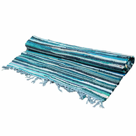 A rolled-up large rag rug with aqua blues and white stripes made of woven fabric with frayed edges