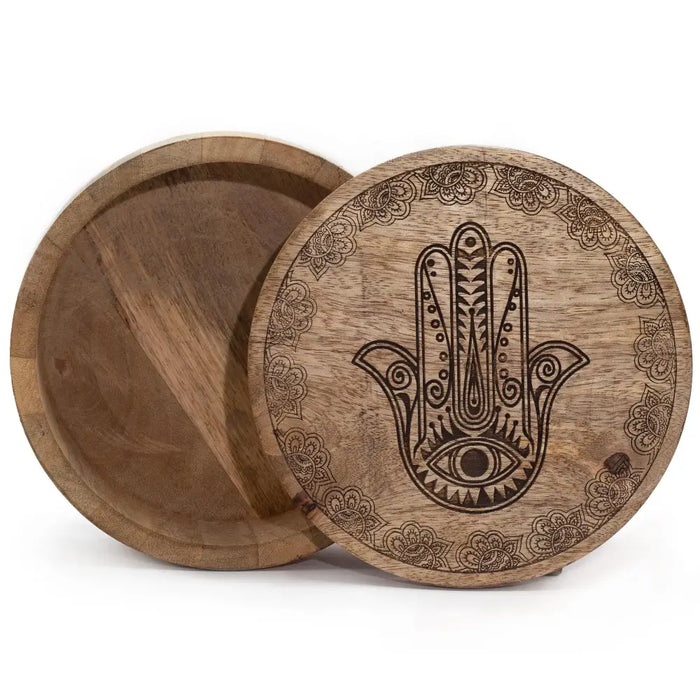 A large round wooden box with a black engraved hamsa hand and floral patterns on the lid