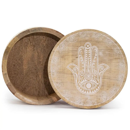 A round wooden box with a light natural finish featuring an engraved hamsa hand and floral border on the lid