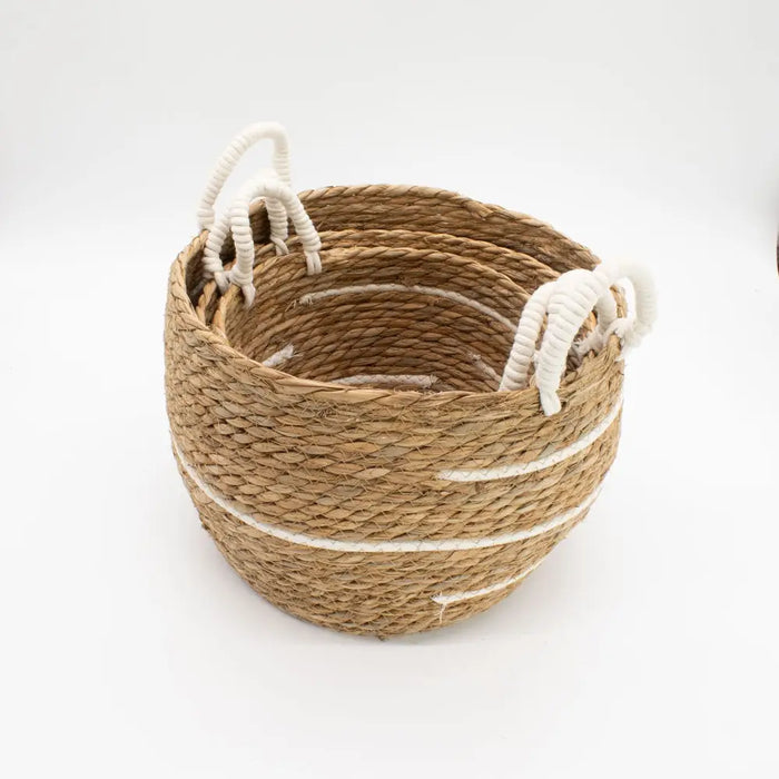 Large natural fiber woven basket with white rope handles and decorative white stripes made from cotton baskets material