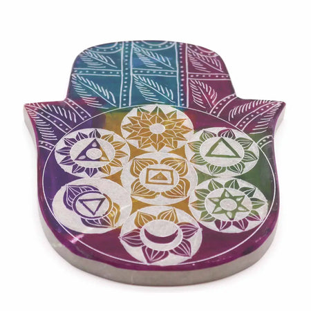 Large soapstone incense holder shaped like a hamsa with gold and white chakra symbols on a teal purple green background