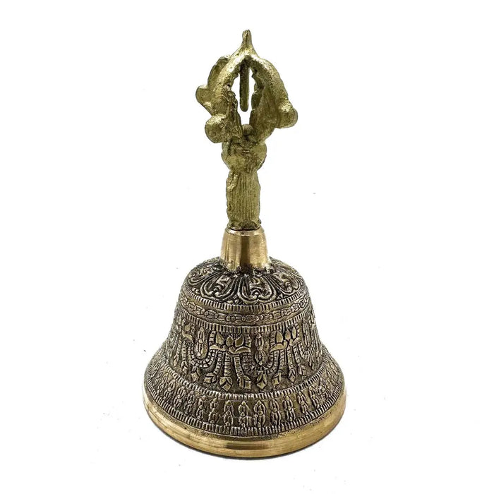 A large brass tibetan tingsha bell with intricate engraved patterns and a decorative handle