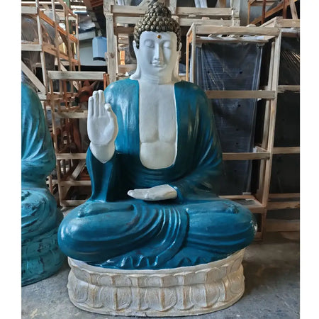 A large turquoise and white stone buddha teaching statue with a golden head seated on a detailed lotus base