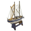Large wooden trawler model with weathered white hull, blue trim, and natural rope sails and netting