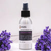 A sleek silver spray bottle of lavender and fennel essential oil mist with witch hazel surrounded by lavender flowers