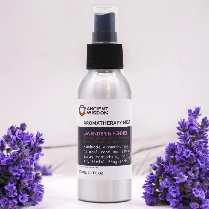 A sleek silver spray bottle of lavender and fennel essential oil mist with witch hazel surrounded by lavender flowers