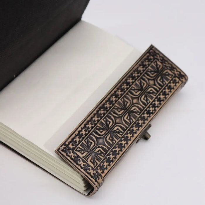 A rectangular leather bookmark with embossed black and tan geometric patterns for an antique grey leather notebook