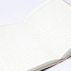 Open leather notebook with cream lined pages and chakra stones design on light brown leather binding 9 by 6 inches