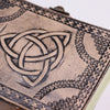 Antique grey leather notebook with embossed circle triquetra and ornate border design measuring 7 by 5 inches