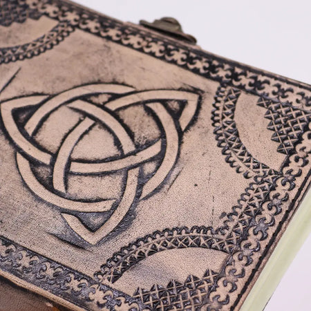 Antique grey leather notebook with embossed circle triquetra and ornate border design measuring 7 by 5 inches