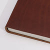Brown leather notebook with dark tan cover and white pages measuring 8 by 6 inches