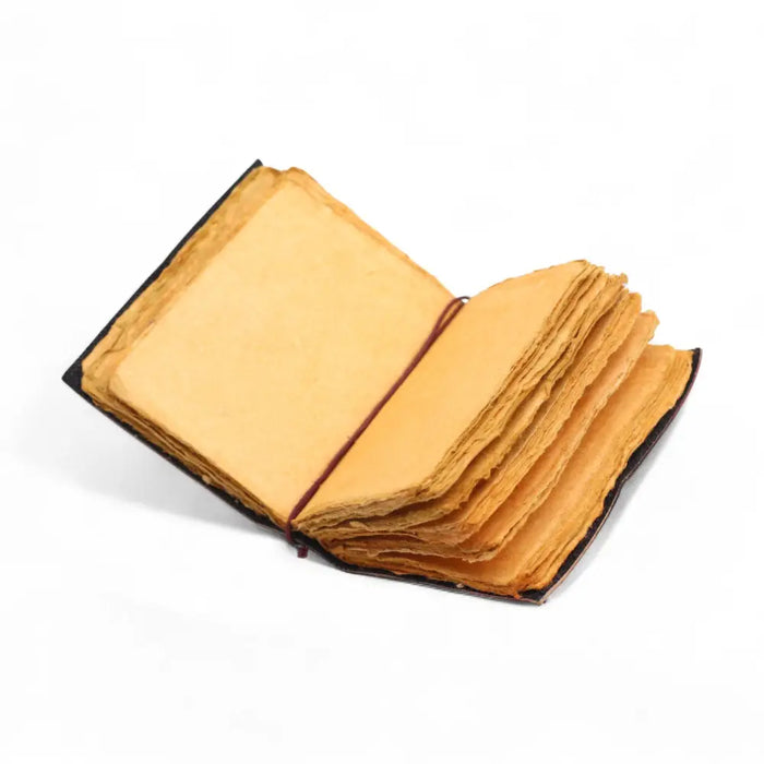 Open leather notebook with yellow aged handmade paper and deckled edges bound by thin brown cord 5x3½ inches
