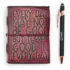 A rich burgundy leather notebook with embossed black lettering and a matching leather strap with deckled edges
