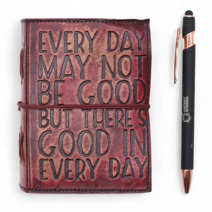 A rich burgundy leather notebook with embossed black lettering and a matching leather strap with deckled edges
