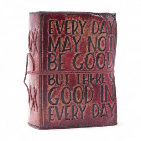 A rustic reddish brown leather notebook with embossed black lettering and a matching cord bound deckled edges design